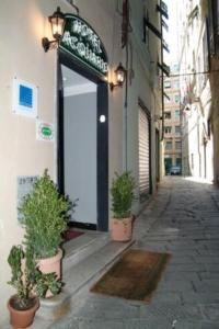 un edificio con un cartel y dos macetas en una calle en Hotel Acquario en Génova