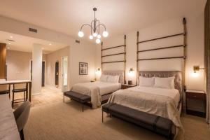 a bedroom with two beds and a chandelier at Hotel Covington Cincinnati Riverfront in Covington
