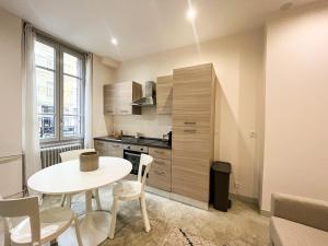 una pequeña cocina con mesa blanca y sillas en una habitación en Suite Onyx, en Lyon