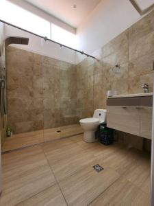een badkamer met een toilet en een glazen douche bij Casa Villa Container in Tibasosa
