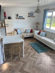 een woonkamer met een bank en een tafel bij Driftwood Lodge in Bideford