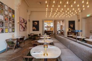 a restaurant with tables and chairs and a couch at Hotel Mercier in Amsterdam