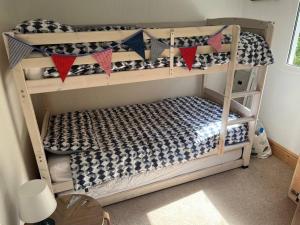 a bedroom with two bunk beds with flags on them at DRIFTWOOD LODGE please note the facilities at the holiday park are seasonal March to November in Bideford