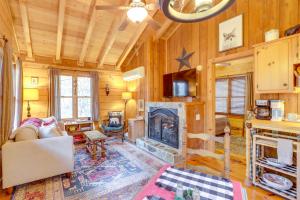 a living room with a fireplace and wooden walls at Little Fox Den Ellijay Cabin Rental with Hot Tub! in Ellijay