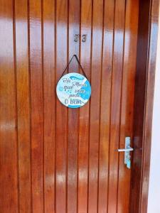 a wooden door with a sign on it at Ap Vista Mar em Caraguatatuba in Caraguatatuba