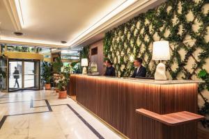 two people sitting at a bar in a lobby at Royal Garden Champs-Élysées in Paris