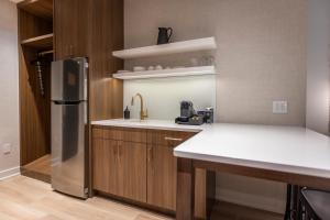 a kitchen with a sink and a refrigerator at Hotel Covington Cincinnati Riverfront in Covington