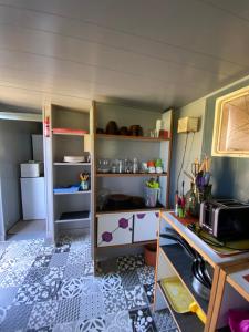 um quarto com uma cozinha com frigorífico e prateleiras em Tente inuit cocooning em Urtaca