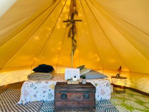 uma cama numa grande tenda amarela em Tente inuit cocooning em Urtaca