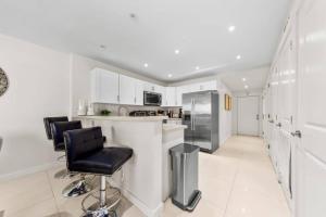 a kitchen with white cabinets and black bar stools at Amazing BahiaMar beachfront 2 steps from amenities in South Padre Island