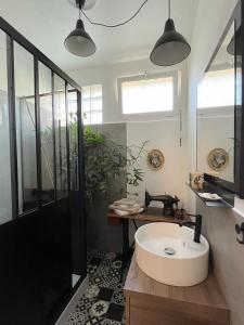 La salle de bains est pourvue d'une baignoire blanche et d'un lavabo. dans l'établissement La Bulle dans le Palmier, à Toulouse