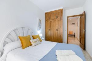 1 dormitorio con 1 cama blanca grande con almohadas amarillas en Fidalsa Bay View Romance en Guardamar del Segura