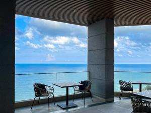 un restaurante con mesas y sillas y vistas al océano en Apec Mandala Wyndham Mui Ne - V Ruby en Ấp Thiẹn Ái