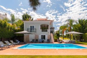 eine Villa mit Swimmingpool und ein Haus in der Unterkunft Villa Simone in Almancil