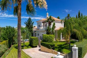 ein großes weißes Haus mit Palmen und Büschen in der Unterkunft Villa Simone in Almancil