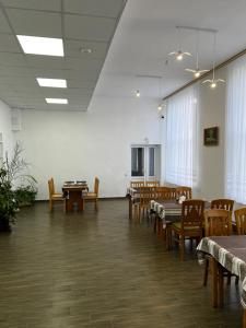 a dining room with tables and chairs and a room with white walls at Готель in Bila Tserkva