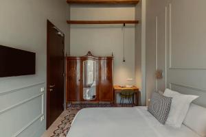 um quarto com uma cama, uma cómoda e uma televisão em La Novieta Boutique Hotel - Adults Only em Valência