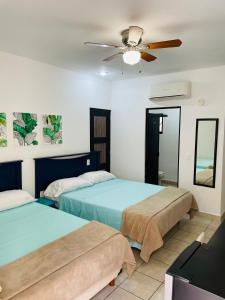 2 camas en una habitación con ventilador de techo en Pedregal Suites - Marina and Downtown en Cabo San Lucas