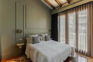 a bedroom with a white bed and a large window at La Novieta Boutique Hotel - Adults Only in Valencia