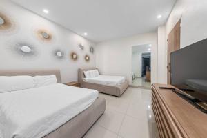 Un dormitorio con dos camas y un televisor de pantalla plana. en Luxury Ground Beachfront Condo Solare 103, en South Padre Island