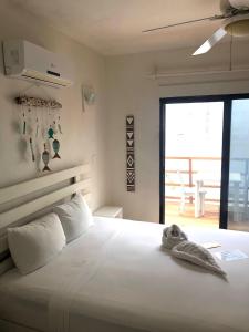 a bedroom with a large white bed with a balcony at Hotel Boutique Pachamama in Mahahual