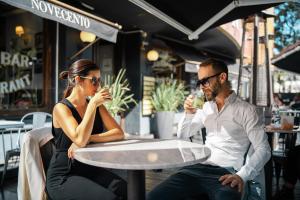 a man and woman sitting at a table in a cafe at Amérian Córdoba Park Hotel in Córdoba