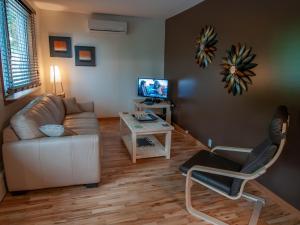 a living room with a couch and a chair at Résidence Touristique Chicoutimi in Saguenay