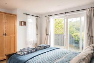 a bedroom with a bed and a large window at Seaside Retreat with Stunning Sea Views in Talland