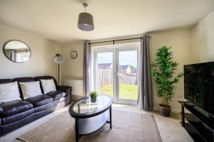 a living room with a couch and a glass table at Wykebeck Mount by Our Home Short Stays in Killingbeck