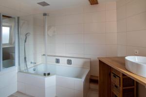 een badkamer met een douche, een wastafel en een bad bij Le Molsheim - Grand appartement proche Musée dArt Moderne in Straatsburg