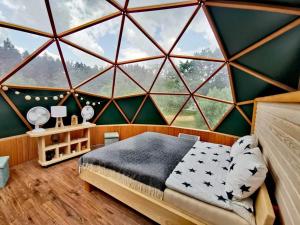 1 dormitorio con una gran ventana de cristal y 1 cama en Šventosios Slėnis, en Grikiapeliai