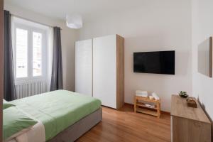 a bedroom with a bed and a tv on a wall at [La Casa di Rinny Circo Massimo] in Rome