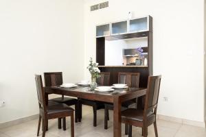 een eetkamer met een houten tafel en stoelen bij Premium stay at the Marina Quays West in Dubai