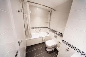 uma casa de banho com um WC, uma banheira e um lavatório. em Crowne Plaza Leeds, an IHG Hotel em Leeds