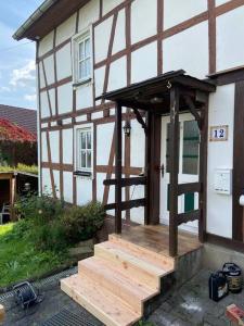 a house with a wooden porch and stairs in front of it at 120 Jahre altes Fachwerkhaus 