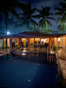 a villa with a swimming pool at night at Ooru homestay in Udupi