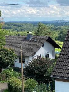 a white house sitting on top of a hill at 120 Jahre altes Fachwerkhaus in Bachenberg