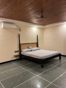a bed in a room with a wooden ceiling at Ooru homestay in Udupi