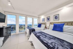 une chambre avec deux lits et une grande fenêtre dans l'établissement Jackpot Beachfront Condo With Amazing Sunset Views, à South Padre Island