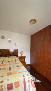 1 dormitorio con 1 cama y armario de madera en Los Girasoles, en La Molina