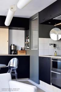 une cuisine noire et blanche avec une table et une chaise dans l'établissement 1 Rue Martin Bucer - Studio dArchi Gare et Petite-France, à Strasbourg