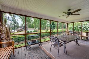 a screened in porch with a table and chairs at Luxe Lake Sinclair Living Private Dock and Beach! in Resseaus Crossroads