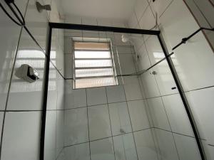 a bathroom with a shower with a window at Apto Santos Gonzaga 50mtrs Praia in Santos