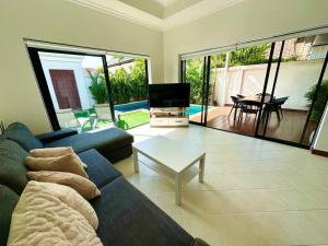 sala de estar con sofá, TV y mesa en View Talay Villas - Luxury 1BR pool villa nr beach - 171, en Jomtien Beach