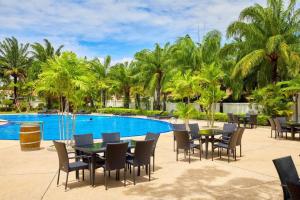 eine Terrasse mit Tischen und Stühlen neben einem Pool in der Unterkunft View Talay Villas - Luxury 1BR pool villa nr beach - 171 in Jomtien Beach
