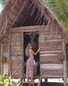 卡馬薩里的住宿－Cabana bem - ti - vi，站在小小屋门口的女人