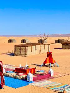 Mhamid Sahara Golden Dunes Camp - Chant Du Sable في Mhamid: صحراء فيها خيمه وسط الصحراء