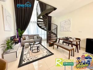 ein Wohnzimmer mit einer Wendeltreppe und einem Tisch in der Unterkunft The Apple Residence By Heystay Management in Malakka