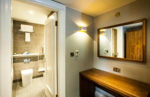 y baño con espejo, lavabo y aseo. en Crowne Plaza Leeds, an IHG Hotel en Leeds