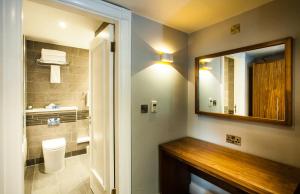 a bathroom with a mirror and a sink and a toilet at Crowne Plaza Leeds, an IHG Hotel in Leeds